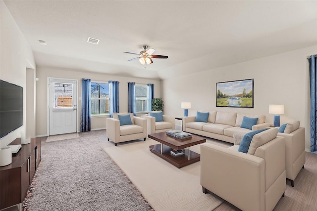 carpeted living area featuring ceiling fan, visible vents, and baseboards