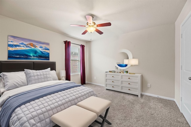 carpeted bedroom with a ceiling fan and baseboards