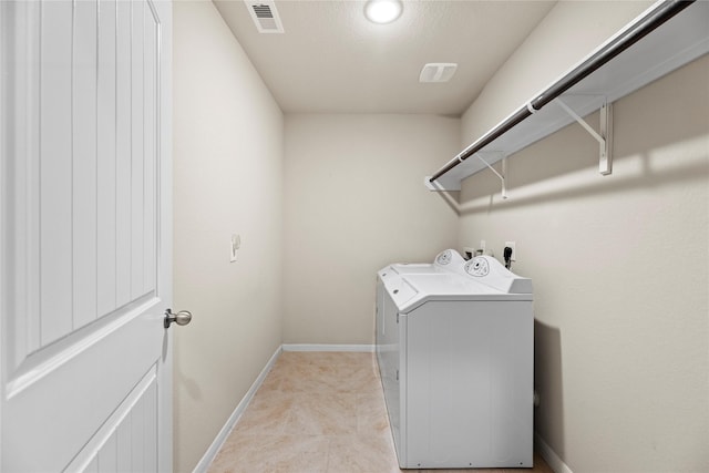 washroom featuring laundry area, baseboards, visible vents, and washing machine and clothes dryer