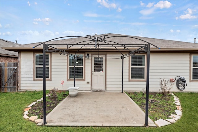 back of house with a yard, a shingled roof, a patio area, and fence