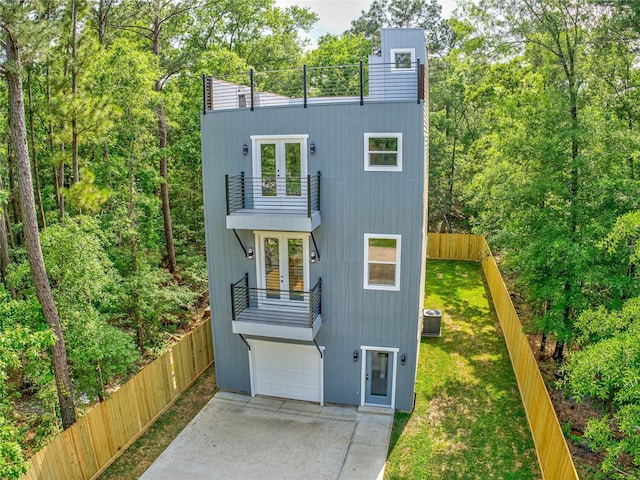 view of front of home featuring french doors, central AC unit, fence, and a balcony