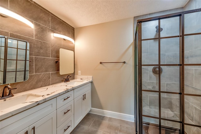 full bath featuring backsplash, a textured ceiling, a tile shower, and a sink