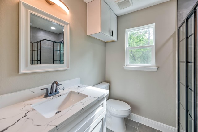 bathroom featuring baseboards, visible vents, a tile shower, and toilet