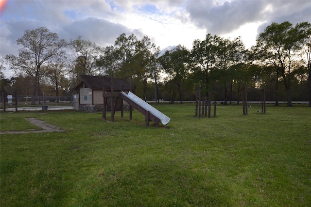 view of jungle gym featuring a lawn and fence