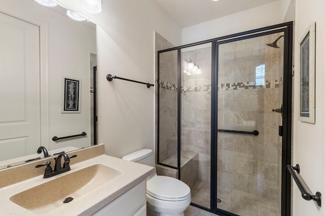 bathroom with vanity, a shower stall, and toilet