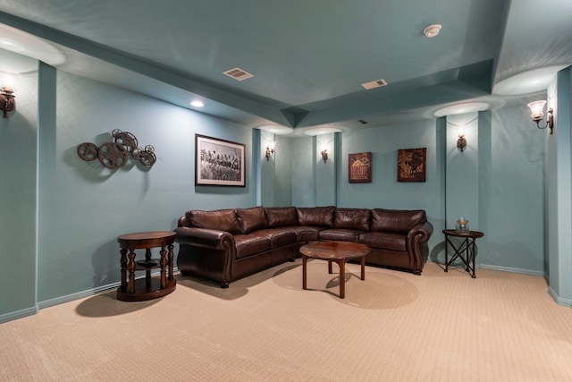 living area featuring baseboards, visible vents, and light colored carpet