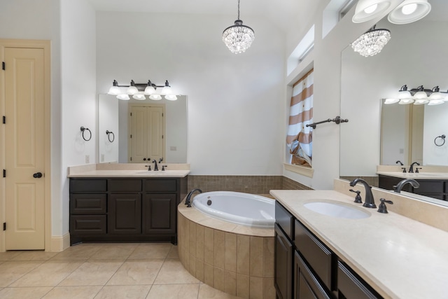 bathroom with a garden tub, a notable chandelier, a sink, and tile patterned floors