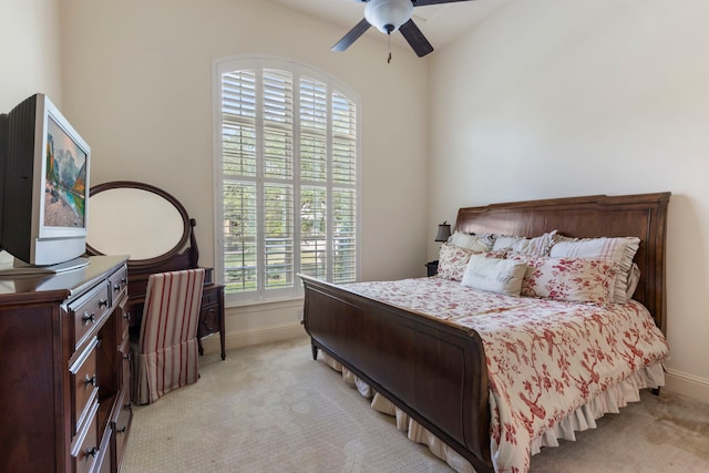 bedroom featuring a ceiling fan, light carpet, and baseboards