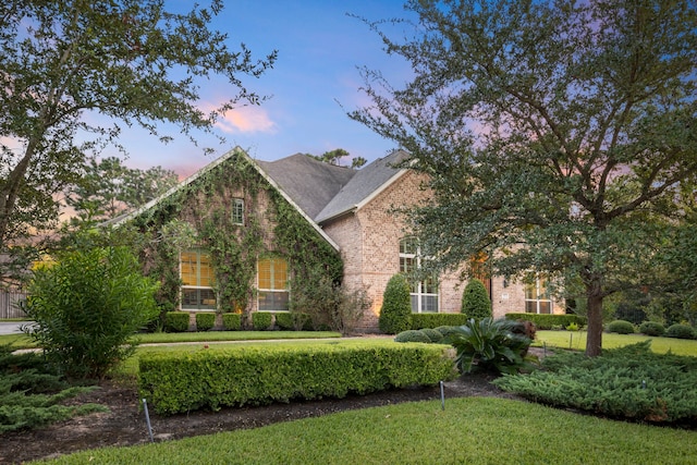 view of front of property featuring a front yard and brick siding