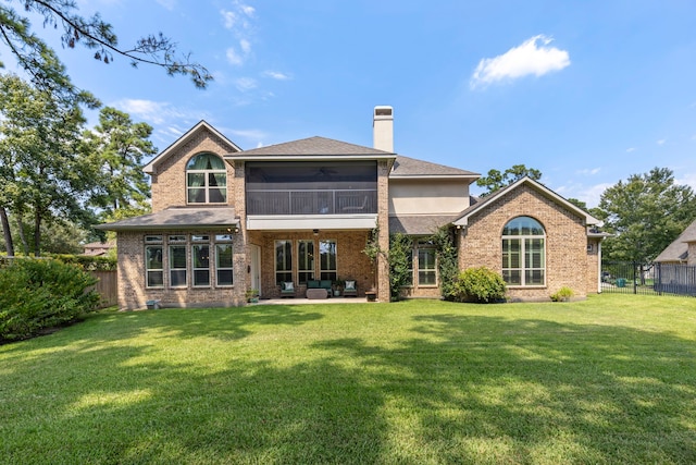 back of house with ceiling fan, a chimney, fence, and a yard