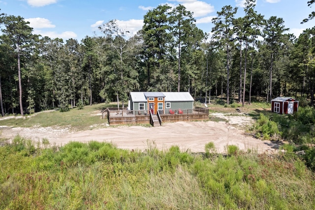 334 County Road 3190, Colmesneil, TX 75938 - view of yard with a wooden deck, dirt driveway, a view of trees, and a storage unit