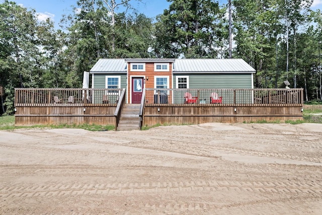 view of front of property featuring metal roof and a wooden deck