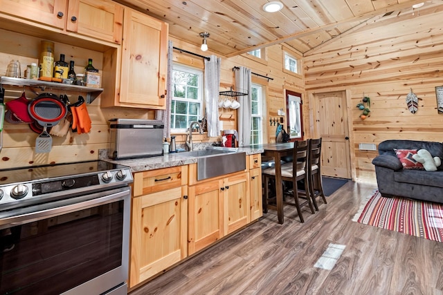 kitchen featuring electric stove, wooden ceiling, light brown cabinetry, wood walls, and a sink