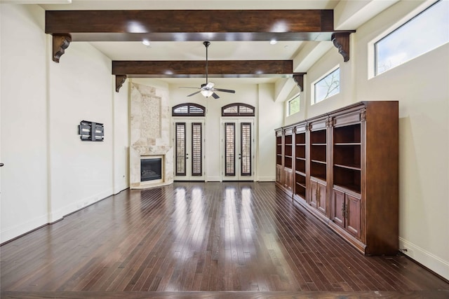 unfurnished living room with a fireplace, baseboards, dark wood-type flooring, and beamed ceiling