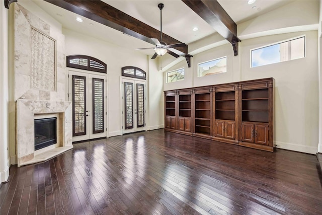 unfurnished living room with high vaulted ceiling, a high end fireplace, baseboards, beamed ceiling, and wood-type flooring