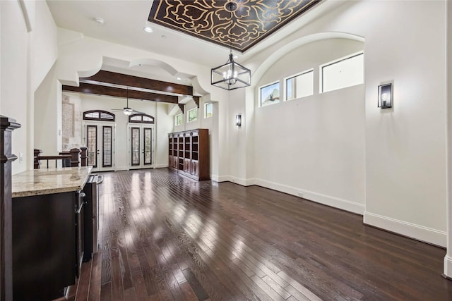 living area featuring beam ceiling, baseboards, dark wood-style flooring, and french doors