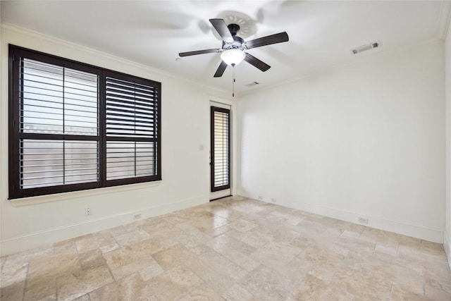 empty room featuring baseboards, ceiling fan, visible vents, and crown molding