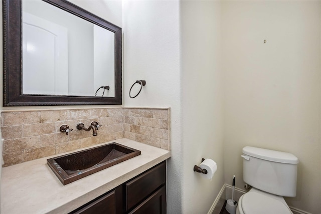 bathroom with toilet, tasteful backsplash, and vanity