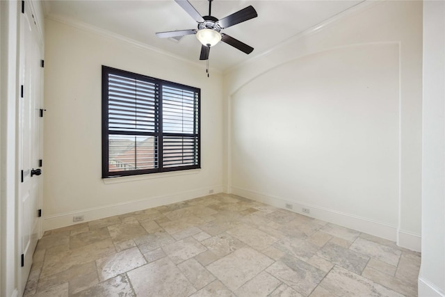 empty room featuring stone tile flooring, a ceiling fan, baseboards, and crown molding