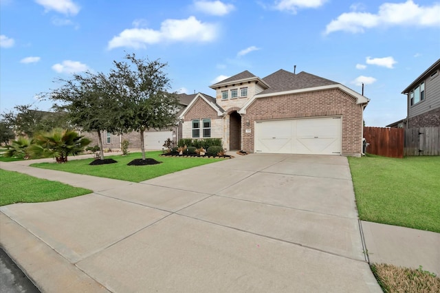 view of front of property with concrete driveway, an attached garage, fence, a front lawn, and brick siding