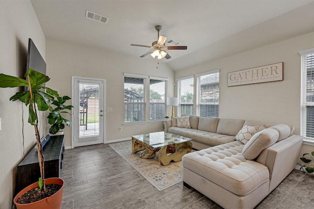 living room featuring a healthy amount of sunlight, baseboards, visible vents, and ceiling fan