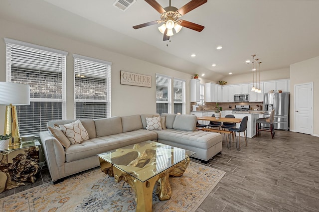 living room featuring recessed lighting, wood finished floors, visible vents, a ceiling fan, and vaulted ceiling