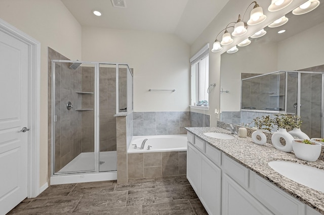 bathroom featuring double vanity, a shower stall, a sink, and a bath