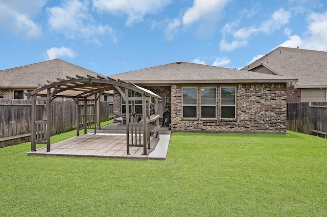 rear view of house with a patio, a fenced backyard, brick siding, a yard, and a pergola