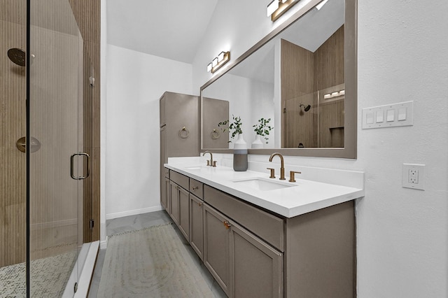 bathroom with double vanity, a shower stall, and a sink