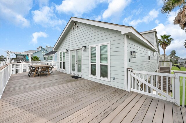 wooden deck featuring outdoor dining area and french doors