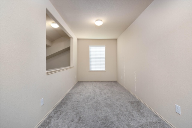 carpeted spare room featuring baseboards