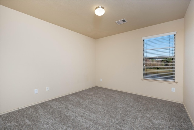 empty room featuring carpet floors and visible vents