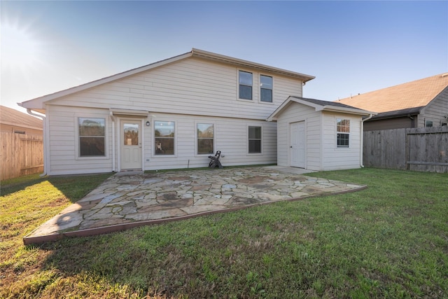 rear view of house with an outbuilding, a yard, a patio area, and a fenced backyard