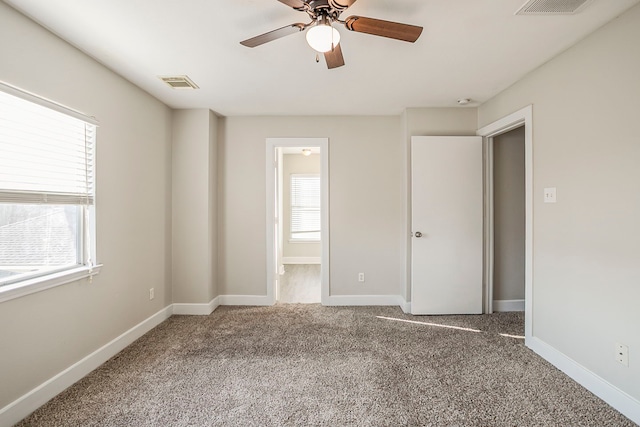 unfurnished bedroom featuring carpet, visible vents, and baseboards