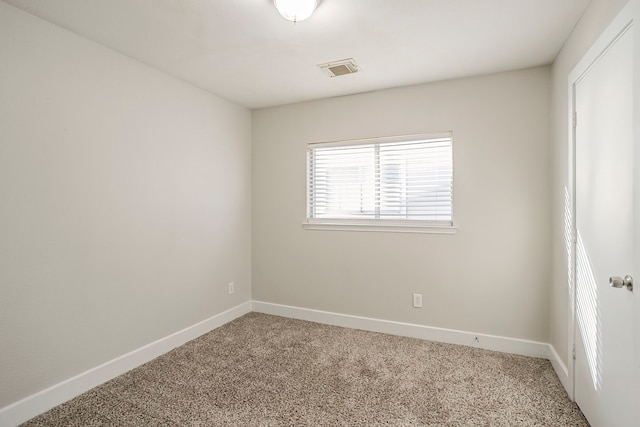 carpeted empty room with visible vents and baseboards