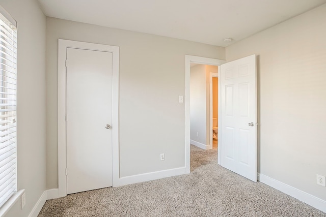 unfurnished bedroom with baseboards and carpet flooring