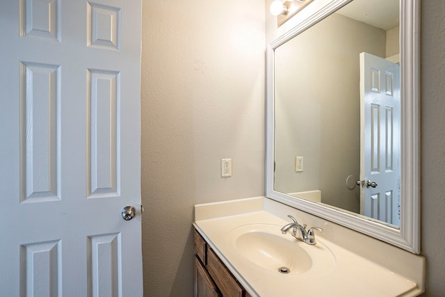 bathroom with a textured wall and vanity