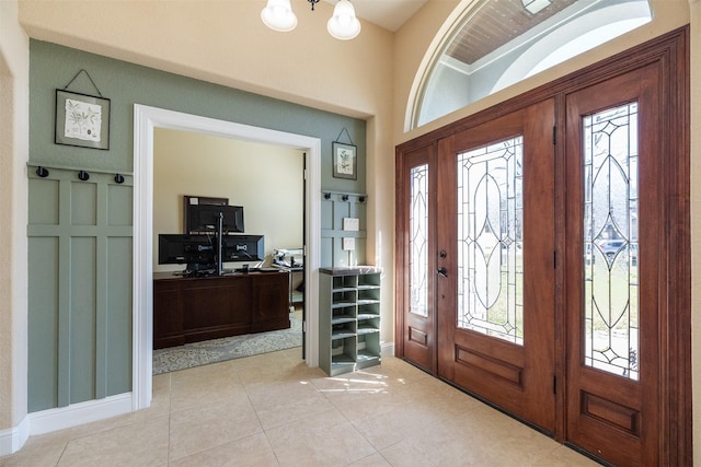 foyer entrance featuring light tile patterned flooring and a notable chandelier