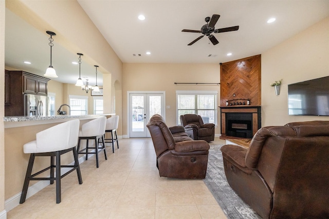 living area featuring french doors, a fireplace, light tile patterned floors, recessed lighting, and visible vents