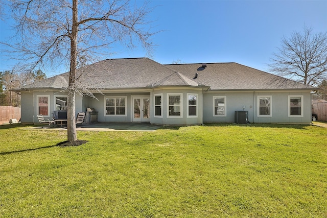 rear view of house with a yard, french doors, fence, and central air condition unit