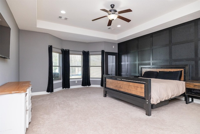 bedroom with recessed lighting, a raised ceiling, light colored carpet, visible vents, and baseboards