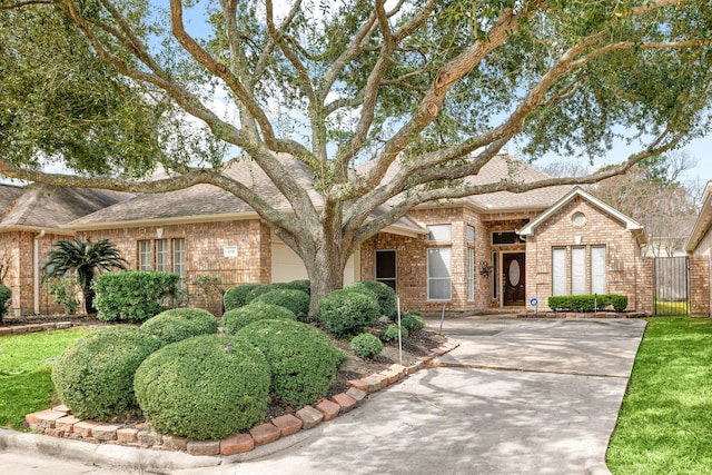 single story home featuring brick siding and roof with shingles