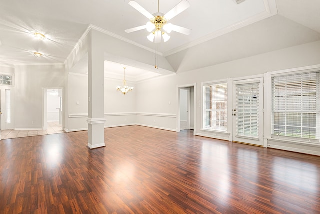 unfurnished living room featuring ceiling fan with notable chandelier, wood finished floors, baseboards, ornamental molding, and ornate columns