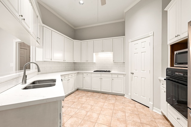 kitchen with decorative backsplash, stainless steel microwave, crown molding, a sink, and black oven