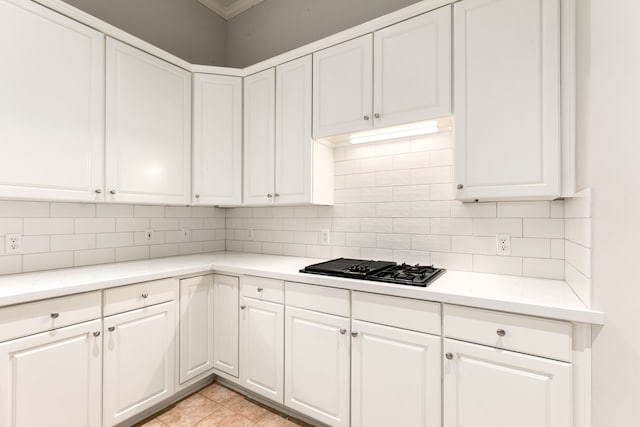 kitchen featuring tasteful backsplash, white cabinetry, and black gas cooktop