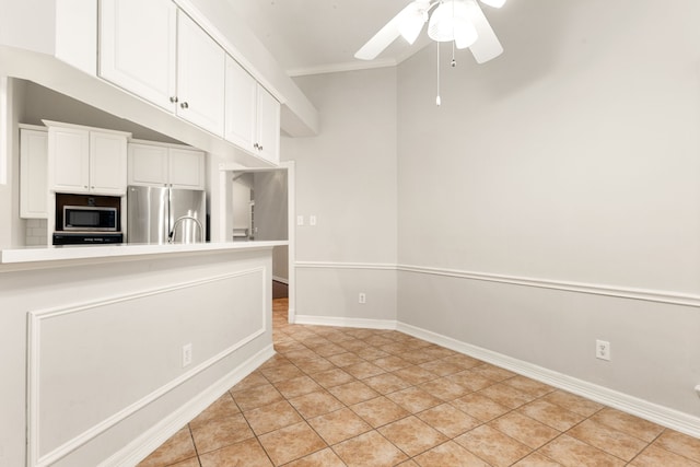 unfurnished room with a ceiling fan, light tile patterned flooring, and baseboards