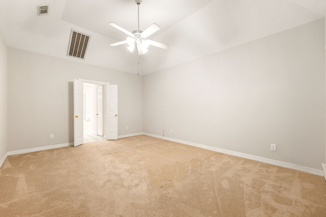 empty room with light carpet, baseboards, visible vents, a ceiling fan, and lofted ceiling