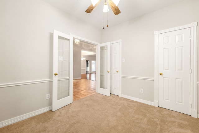 unfurnished bedroom with carpet floors, french doors, a ceiling fan, and baseboards