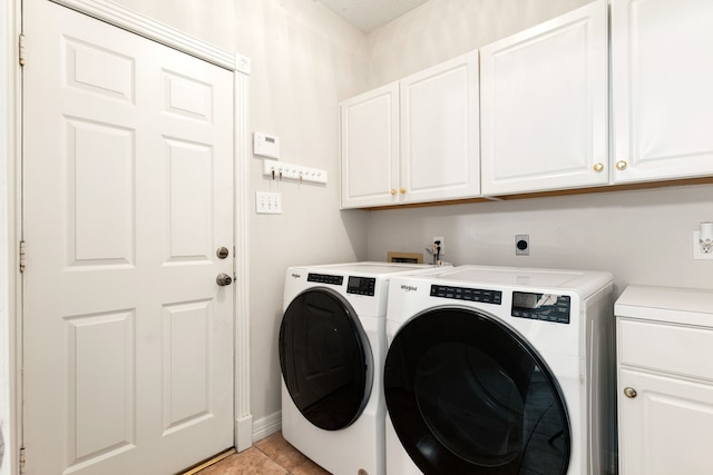 washroom with cabinet space, washing machine and dryer, light tile patterned floors, and baseboards