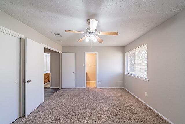 unfurnished bedroom with carpet floors, baseboards, visible vents, and a textured ceiling